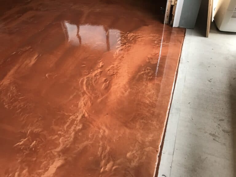 A garage floor with a brown coating on it.