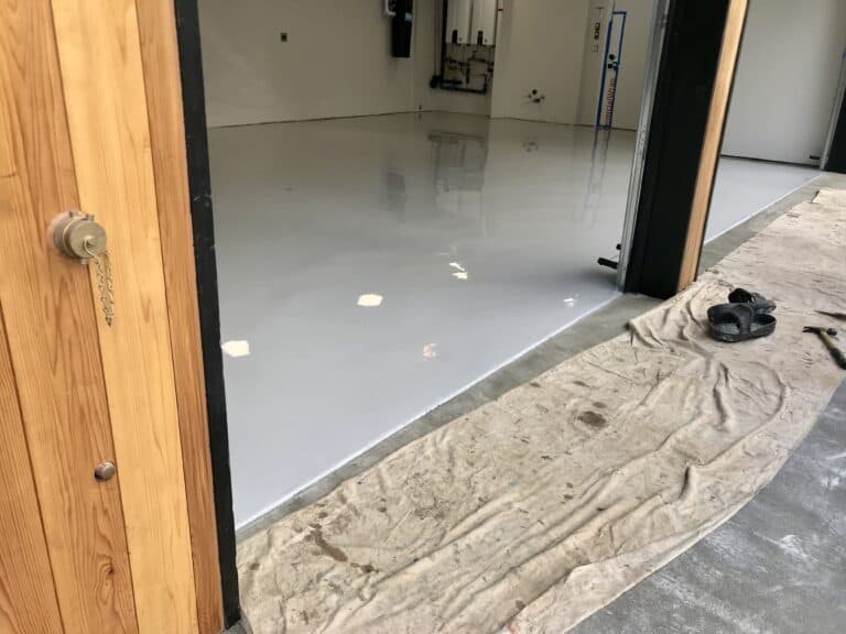 A garage with a white floor and a door.