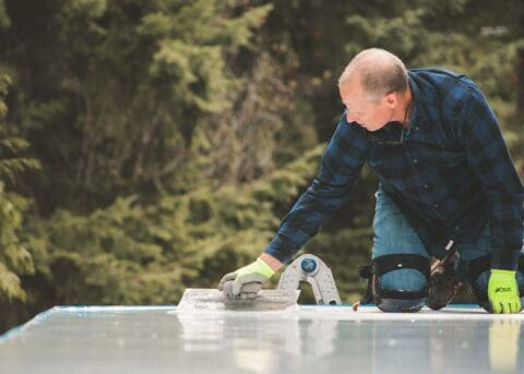 a professional contractor coating a deck to waterproof it