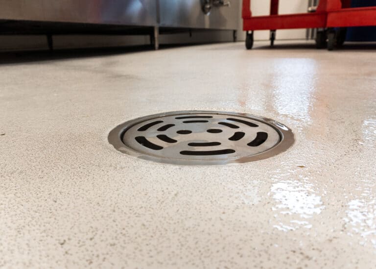 A drain in the floor of a kitchen.