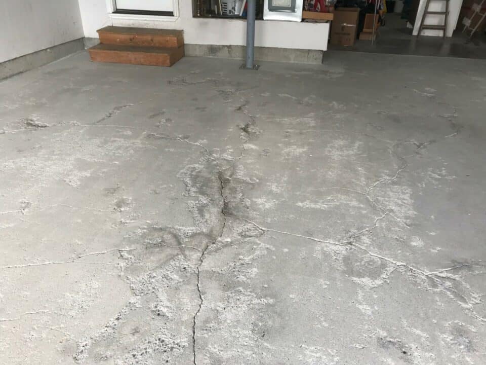 a garage floor with multiple cracks in the concrete